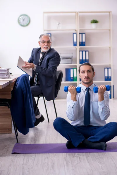 Due dipendenti che fanno esercizi fisici sul posto di lavoro — Foto Stock