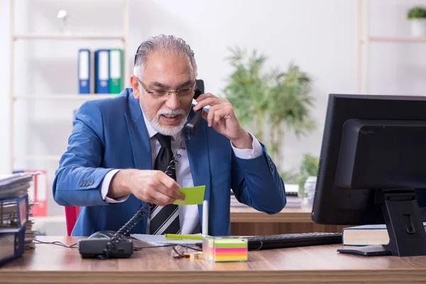 Old male employee and excessive work in the office — Stock Photo, Image