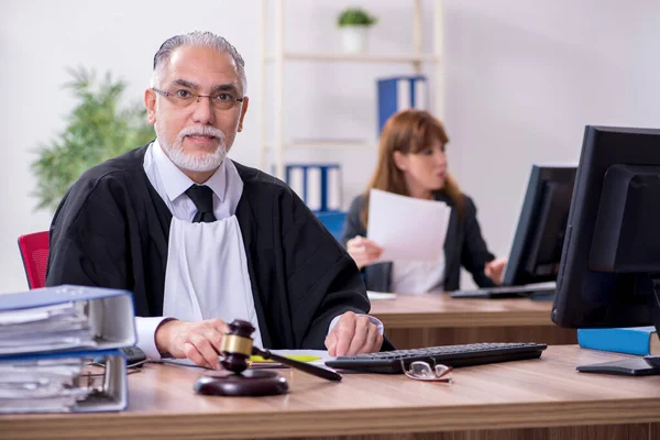 Viejo juez y su joven secretaria en la oficina — Foto de Stock