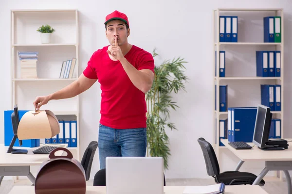Young male courier delivering cake to the office — Stock Photo, Image