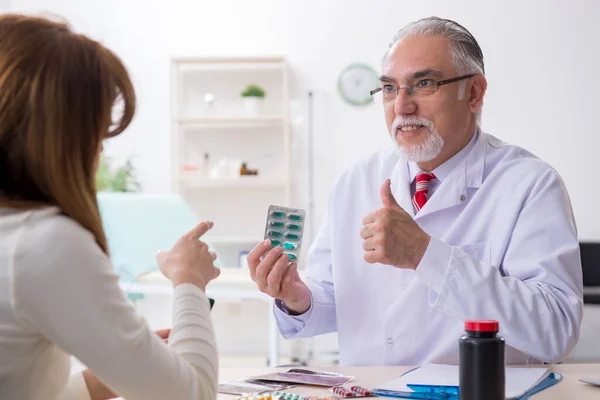 Jonge vrouw op bezoek bij ervaren arts — Stockfoto