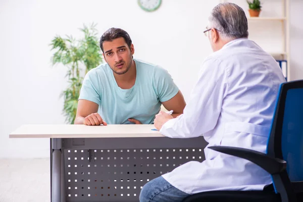 Ung manlig patient besöker erfaren läkare — Stockfoto