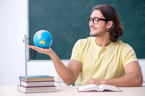 Young male geography teacher in front of blackboard — Stock Photo, Image