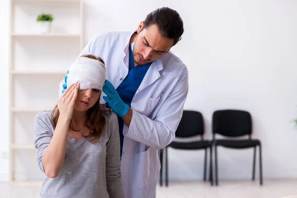 젊은 남성 의사를 방문하는 젊은 머리 부상 여성 — 스톡 사진
