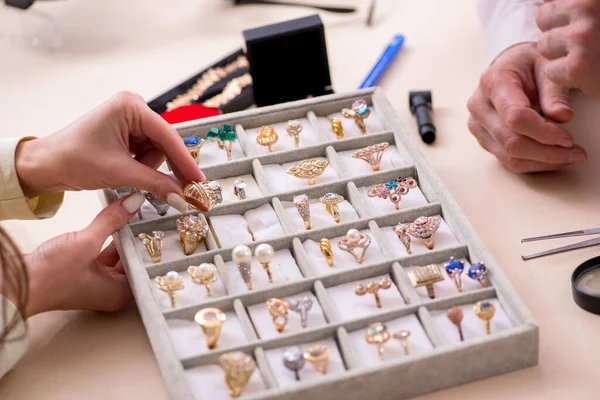 Genç bir kadın yaşlı bir erkek kuyumcuyu ziyaret ediyor.