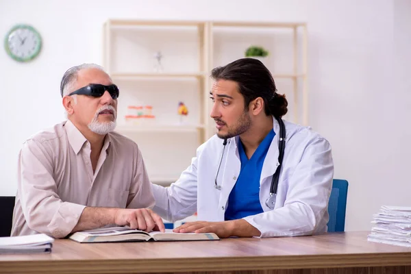 Слепой старик навещает молодого врача — стоковое фото