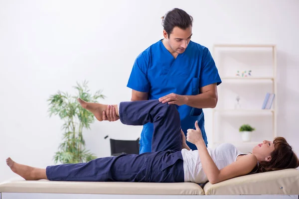 Skadad kvinna besöker ung manlig läkare osteopat — Stockfoto