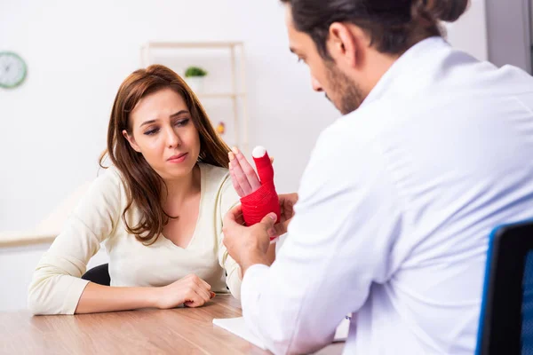 Jovem mão ferida mulher visitando médico traumatologista masculino — Fotografia de Stock