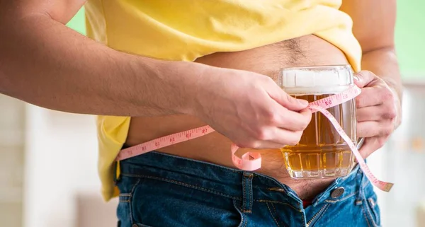Hombre midiendo grasa corporal con cinta métrica en concepto de dieta —  Fotos de Stock