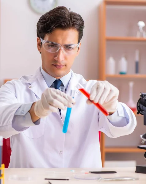 Jeune beau biochimiste travaillant dans le laboratoire — Photo