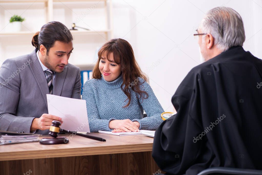 Young woman in courthouse with judge and lawyer