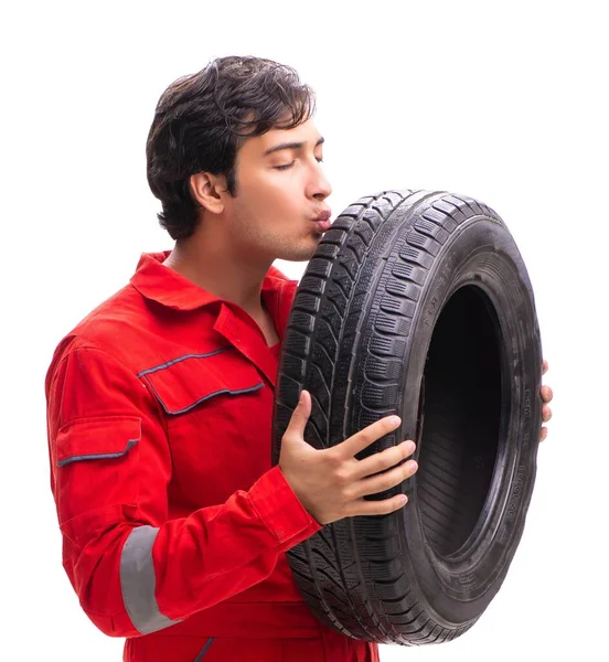 Joven trabajador de garaje con neumático aislado en blanco —  Fotos de Stock