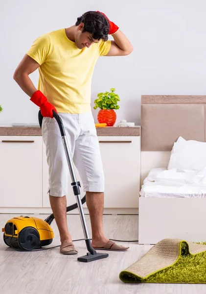 Jovem homem bonito limpeza no quarto — Fotografia de Stock