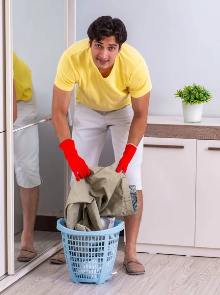 Giovane uomo bello pulizia in camera da letto — Foto Stock