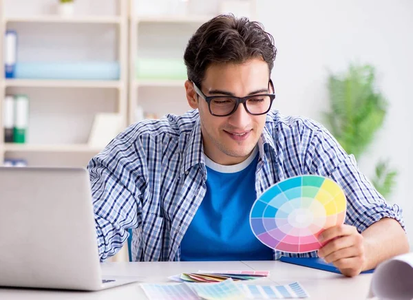 Joven diseñador trabajando en un nuevo proyecto y eligiendo colores —  Fotos de Stock