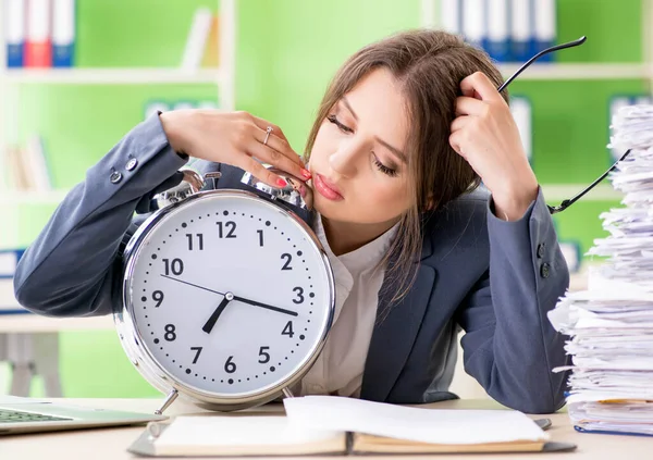 Jonge vrouwelijke werknemer zeer druk met lopende papierwerk in de tijd m — Stockfoto