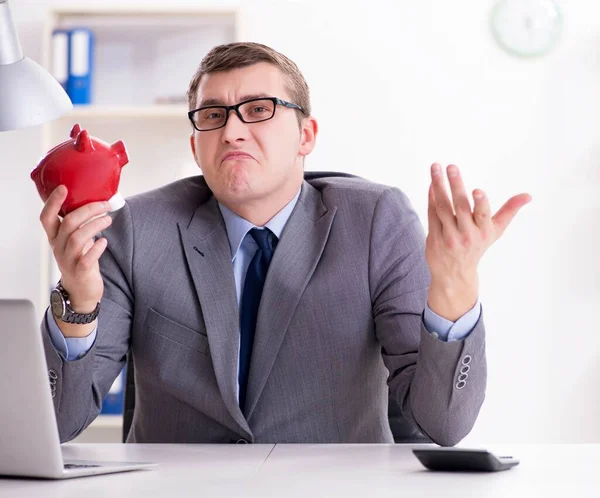 Mladý zaměstnanec s piggybank v penzijním spoření koncept — Stock fotografie