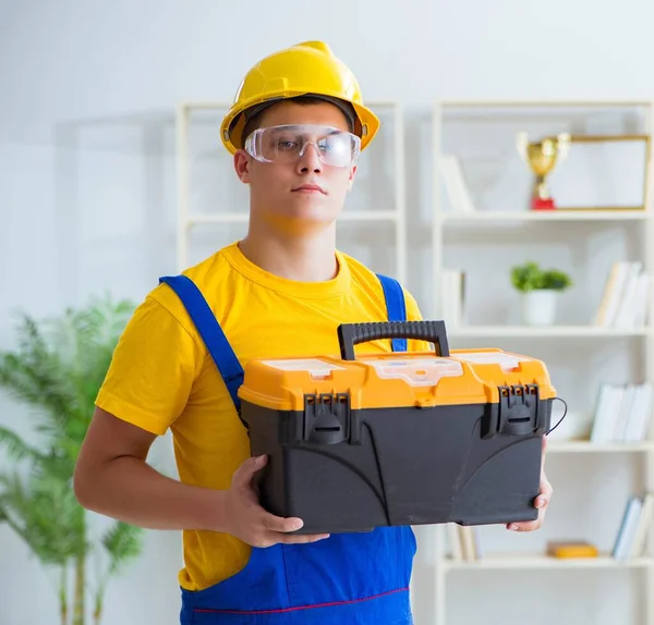 Jovem empreiteiro fazendo obras de reparação no escritório — Fotografia de Stock