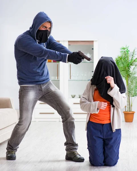 Ozbrojený muž napadá mladou ženu doma — Stock fotografie