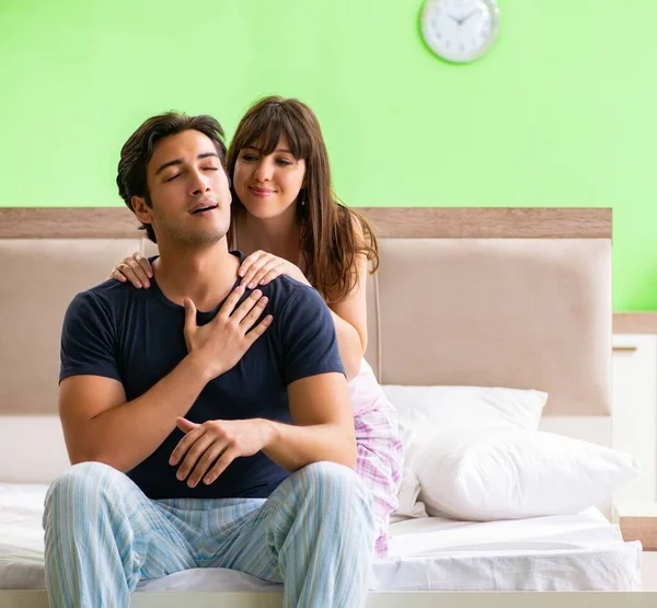 Woman doing massage to her husband in bedroom — Stock Photo, Image