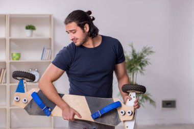 Kaykay tamir eden genç bir erkek tamirci.