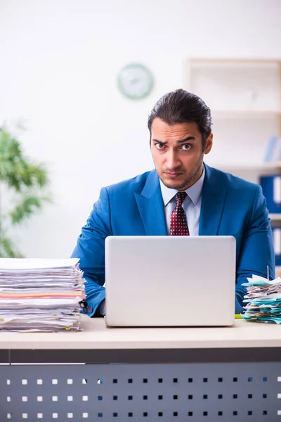 Ung manlig anställd missnöjd med överdrivet arbete — Stockfoto