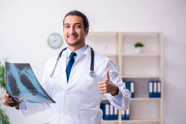 Mladý mužský pohledný lékař pracující na klinice — Stock fotografie