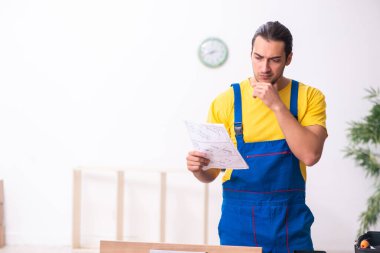 Genç erkek marangoz içeride çalışıyor.