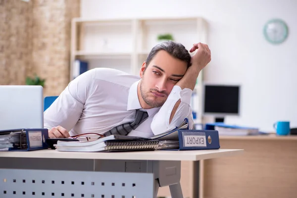 Joven empleado masculino infeliz con el trabajo excesivo — Foto de Stock