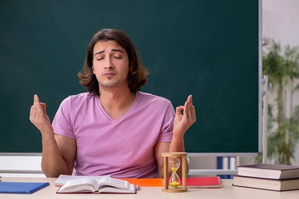 Junge männliche Schüler im Klassenzimmer bei Zeitmanagement-Konzept — Stockfoto