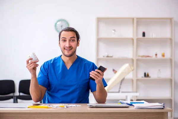 Mladý mužský lékař pracující na klinice — Stock fotografie