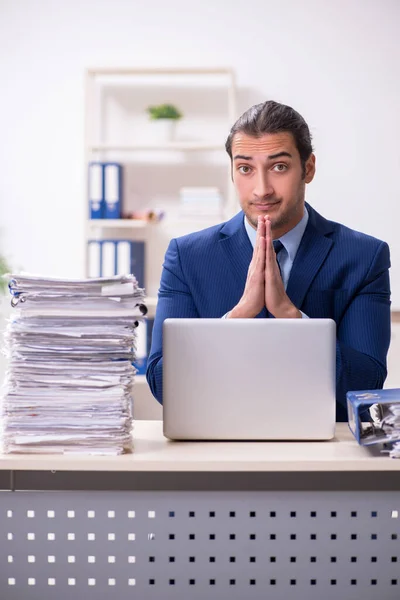 Joven empleado masculino infeliz con el trabajo excesivo — Foto de Stock