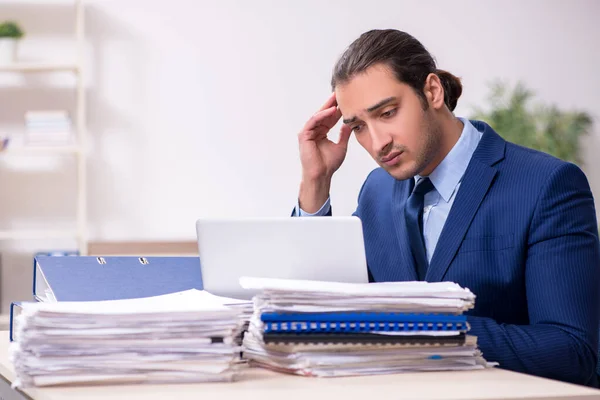 Joven empleado masculino infeliz con el trabajo excesivo — Foto de Stock