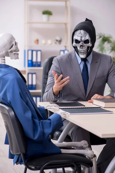Divertido encuentro de negocios con el diablo y los esqueletos — Foto de Stock