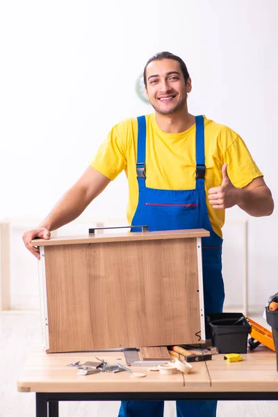 Junger Tischler arbeitet drinnen — Stockfoto