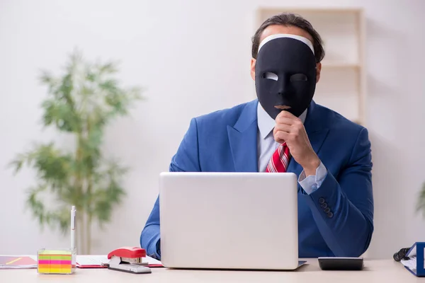Dipendente maschile con maschera nel concetto di ippocrisia — Foto Stock