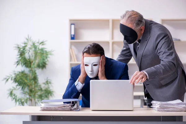 Gammal chef och ung manlig anställd bär masker — Stockfoto