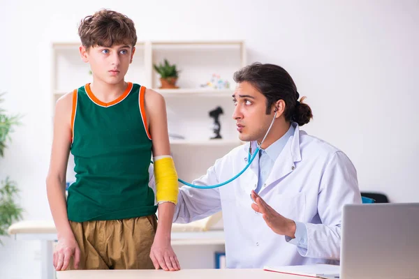 Beteg fiú látogató fiatal férfi orvos gyermekorvos — Stock Fotó