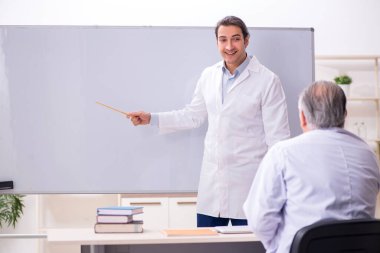Deneyimli doktor genç erkek asistana öğretiyor.
