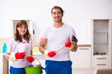 Genç çift evde ev işi yapıyor.