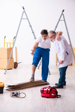 Deneyimli sağlık görevlisi yılan tarafından ısırılan işçiye yardım ediyor.