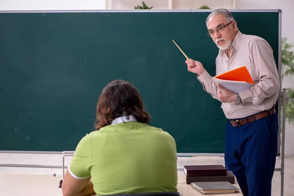 Oude hoogleraar natuurkunde en jonge student in de klas — Stockfoto