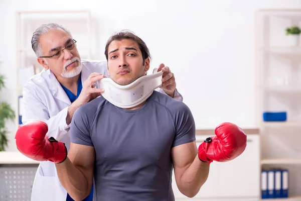 Genç yaralı boksör yaşlı doktor travmatoloğu ziyaret ediyor. — Stok fotoğraf