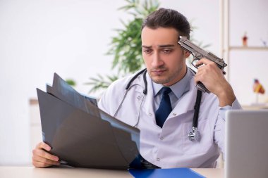 Klinikte çalışan genç erkek doktor.