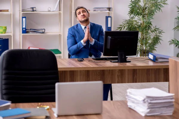 Joven empleado masculino infeliz con el trabajo excesivo —  Fotos de Stock