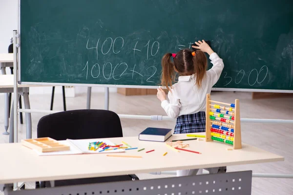 Klein meisje voor schoolbord in de klas — Stockfoto