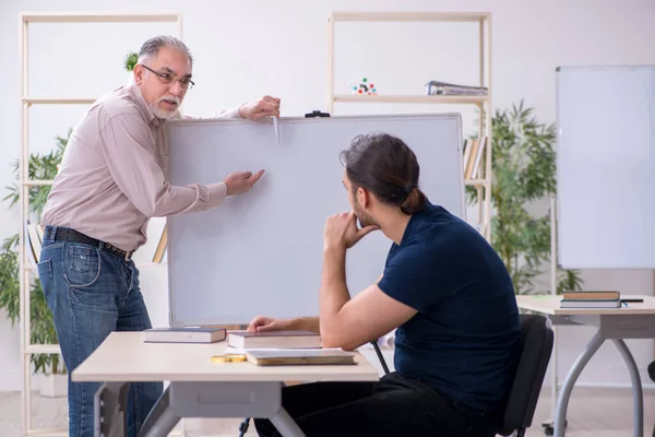 Alt lehrer und jung männlich student im die klassenzimmer — Stockfoto