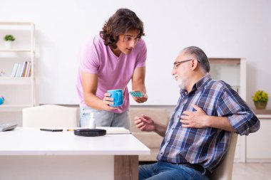 Genç öğrenci ve yaşlı büyükbabası evde.