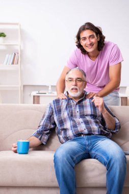 Genç öğrenci ve yaşlı büyükbabası evde.