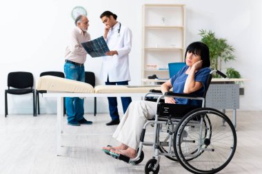 Yaşlı çift genç erkek doktoru ziyaret ediyor.